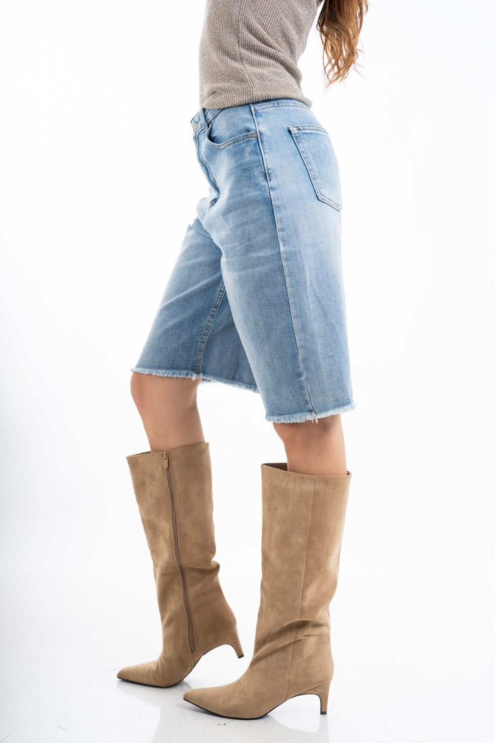 modella indossando Bermuda in denim con orlo sfrangiato e vestibilità dritta colore Denim Medio