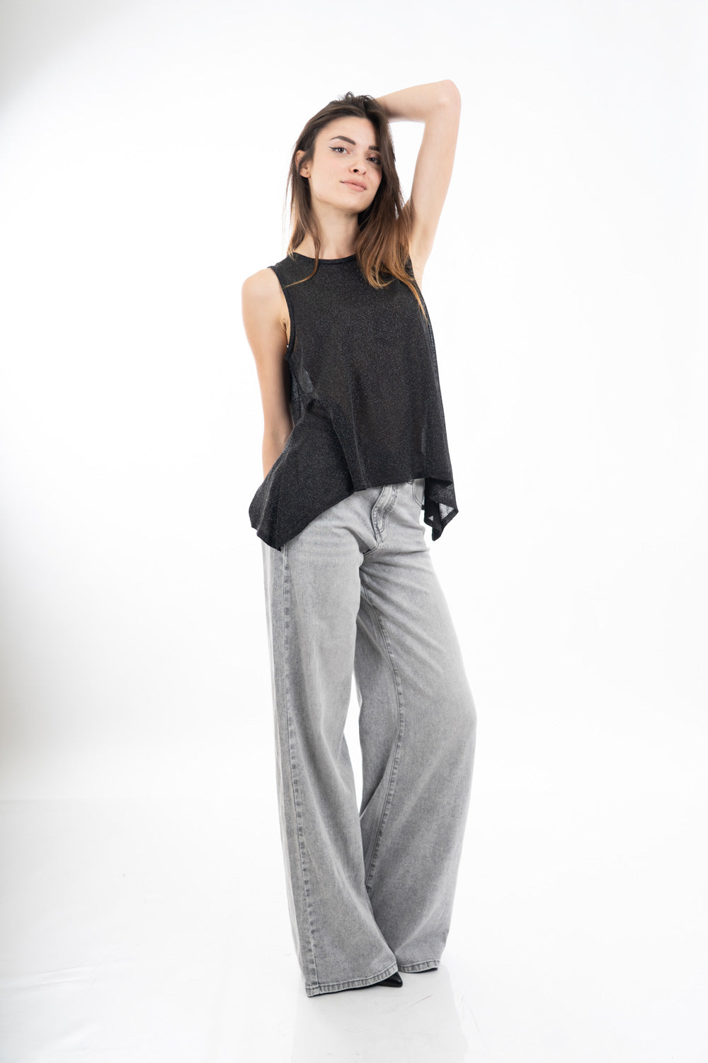 modella indossando Top smanicato in viscosa lurex leggero e semitrasparente, linea svasata e vestibilità morbida. Perfetto per look casual o eleganti. colore