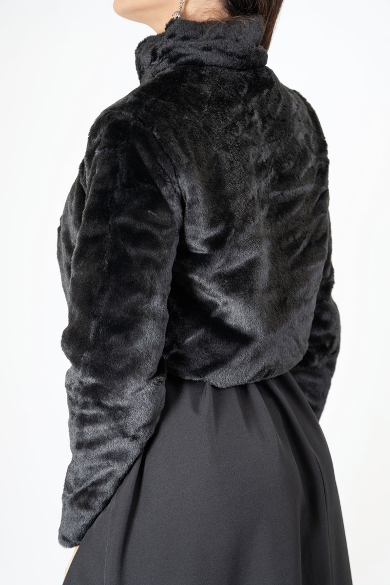 modella indossando Bolero corto in ecopelliccia con bottone gioiello colore