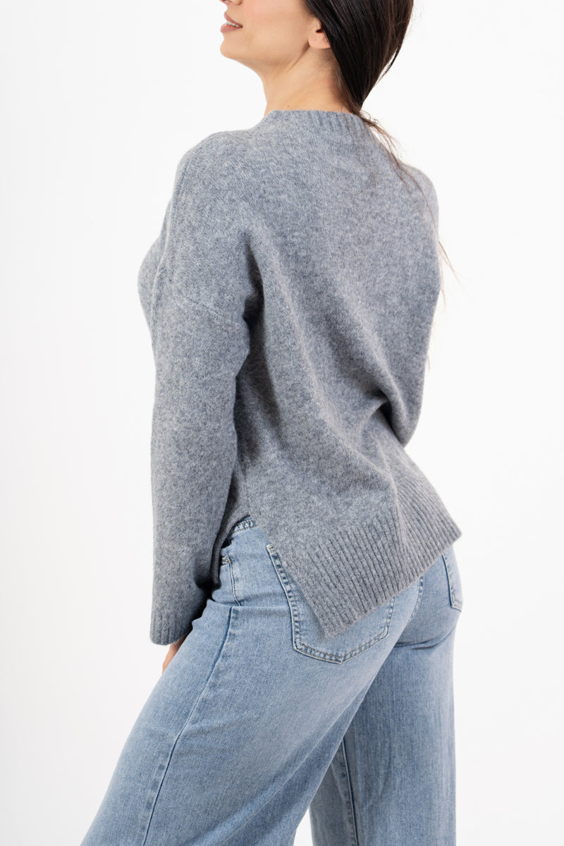 modella indossando Maglione over girocollo con fondo asimmetrico e spacchi laterali colore