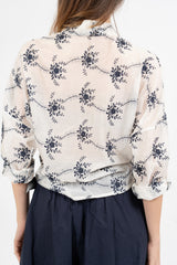 Camicia ampia in tencel velato con ricami floreali.