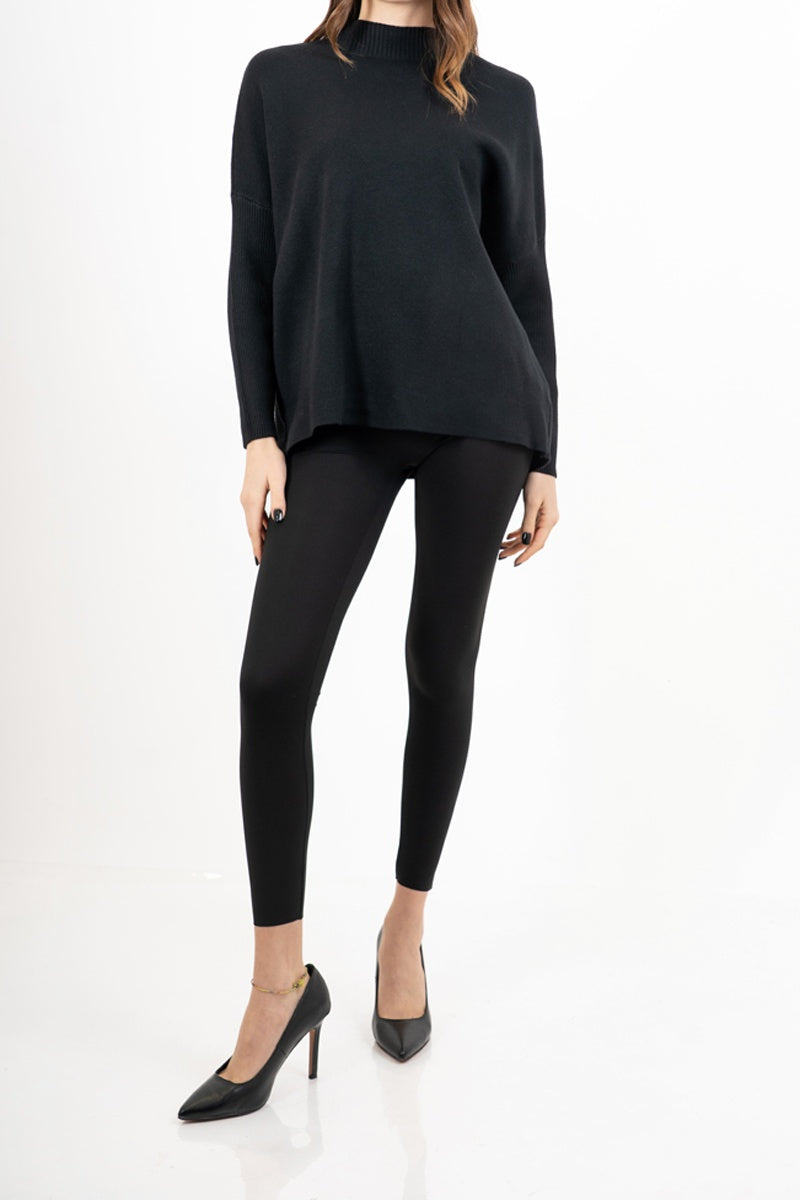 modella indossando Maglia over corta in filato caldo con maniche a costine e collo alto colore Nero Unica