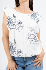 Blusa ricamata in tencel con spalle ad aletta e fondo balloon.