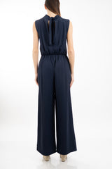 modella indossando Tuta elegante palazzo in tessuto tecnico con apertura a goccia e fusciacca colore