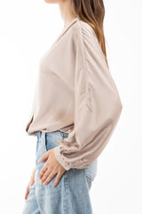modella indossando Blusa in raso fluido con scollatura incrociata e maniche a palloncino colore