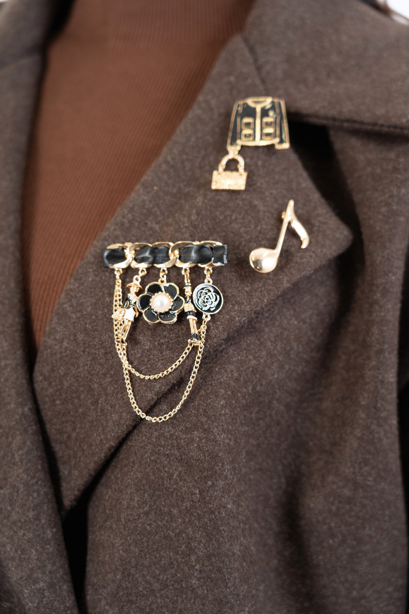 modella indossando Spilla decorativa con charms e catene oro colore Nero