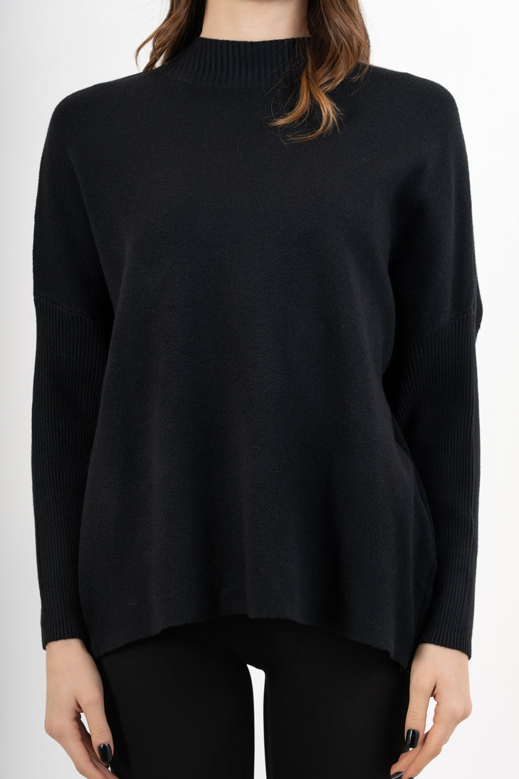 modella indossando Maglia over corta in filato caldo con maniche a costine e collo alto colore