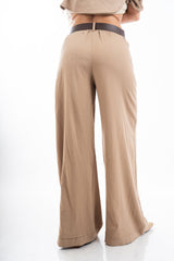 modella indossando Pantalone palazzo con elastico in vita, tasche e cintura inclusa effetto naturale colore