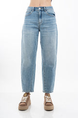 modella indossando Jeans balloon in denim elasticizzato con fondo taglio vivo colore Denim Medio