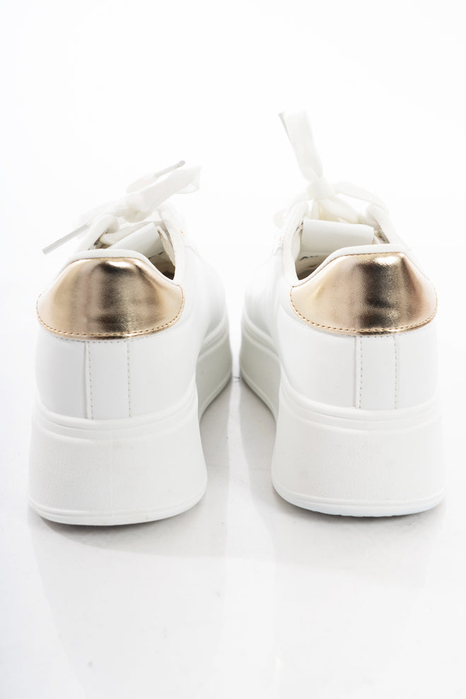 modella indossando Sneakers platform bianche con charm gioiello – dettaglio oro colore