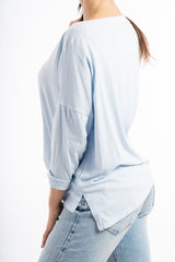 modella indossando Maglia over in cotone elasticizzato con scollo ampio e spacchi laterali colore