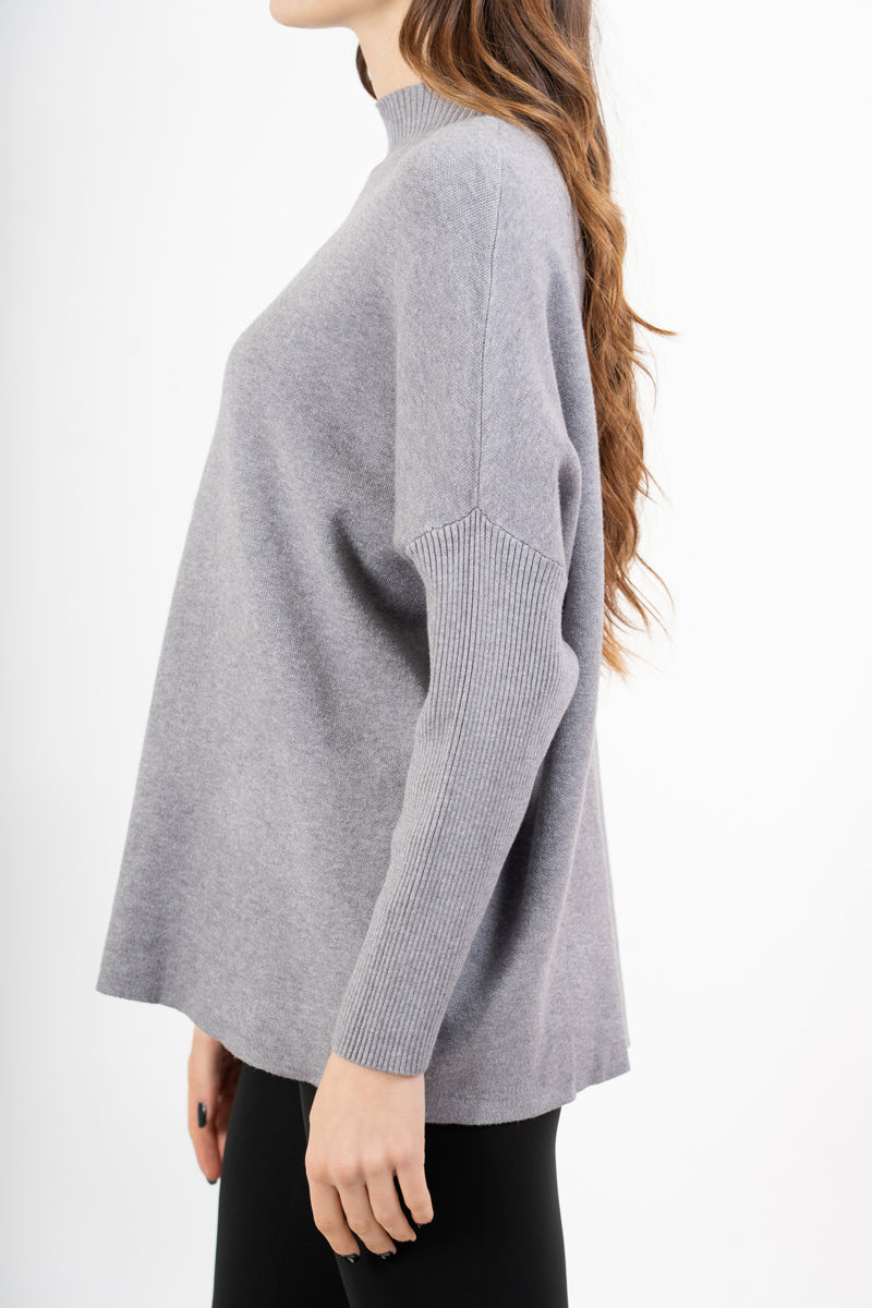 modella indossando Maglia over corta in filato caldo con maniche a costine e collo alto colore