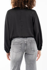 modella indossando Blusa in raso fluido con scollatura incrociata e maniche a palloncino colore