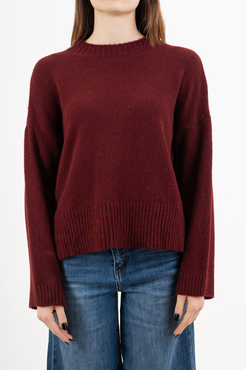 modella indossando Maglione over girocollo con fondo asimmetrico e spacchi laterali colore BORDEAUX Unica