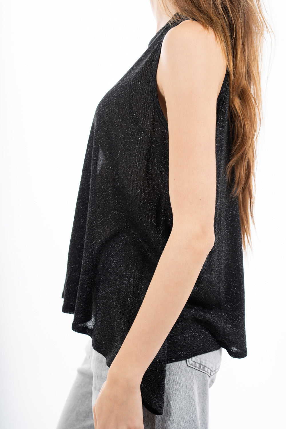 modella indossando Top smanicato in viscosa lurex leggero e semitrasparente, linea svasata e vestibilità morbida. Perfetto per look casual o eleganti. colore