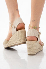 Espadrillas oro chiuse con zeppa in corda e cinturino alla caviglia.