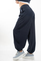 modella indossando Pantalone carrot gessato con pinces e fondo elasticizzato colore