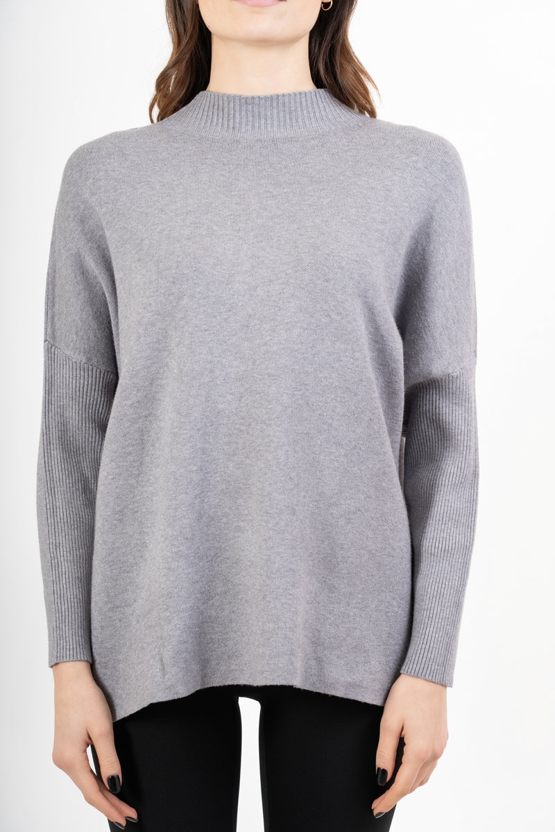 modella indossando Maglia over corta in filato caldo con maniche a costine e collo alto colore