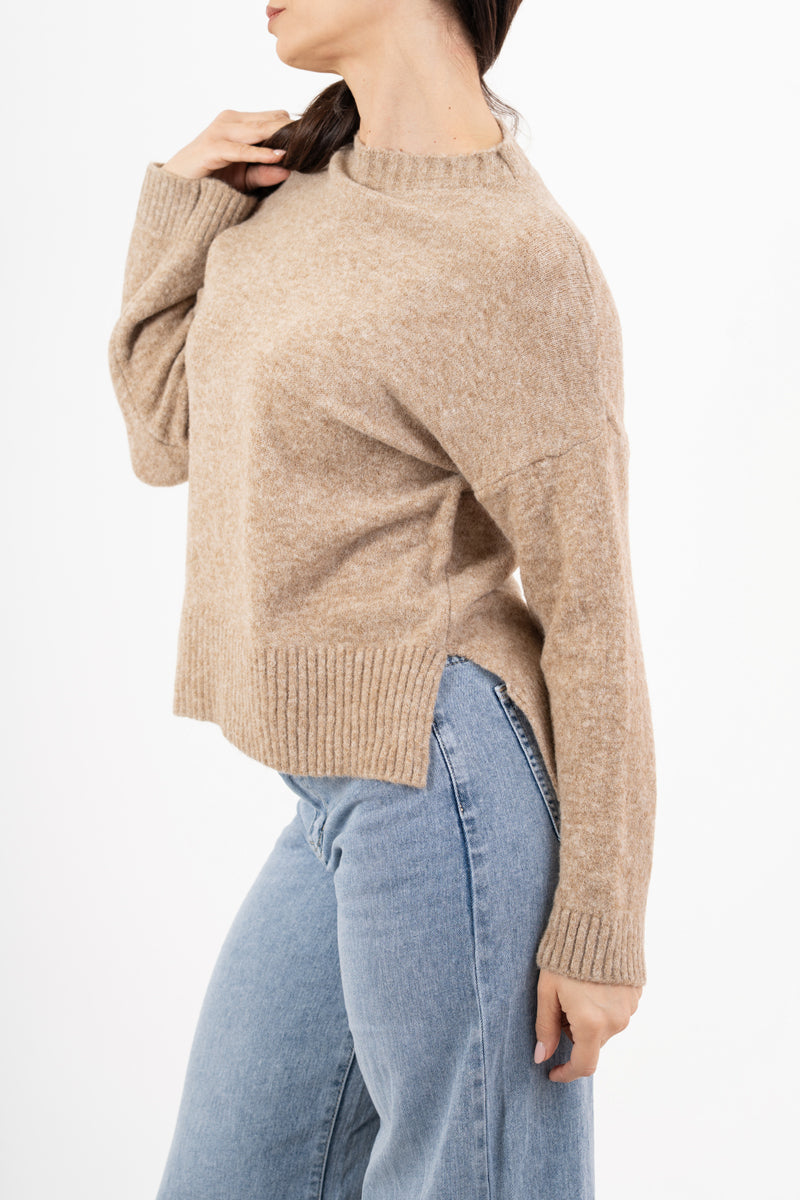 modella indossando Maglione over girocollo con fondo asimmetrico e spacchi laterali colore Beige Unica