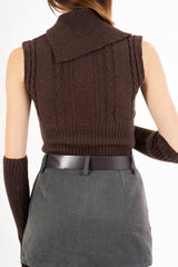 modella indossando Maglia smanicata a trecce con collo alto e bottoni laterali colore