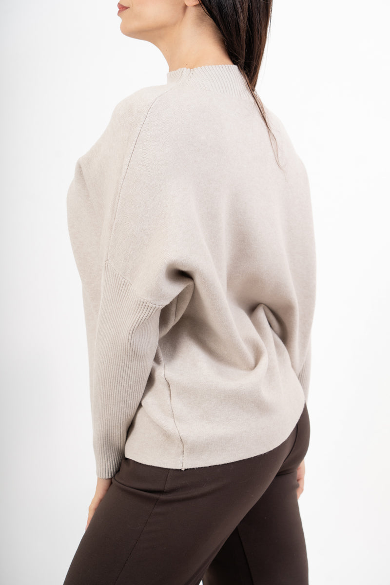 modella indossando Maglia over corta in filato caldo con maniche a costine e collo alto colore