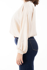 modella indossando Blusa in raso fluido con scollatura incrociata e maniche a palloncino colore