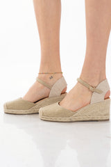 Espadrillas oro chiuse con zeppa in corda e cinturino alla caviglia.